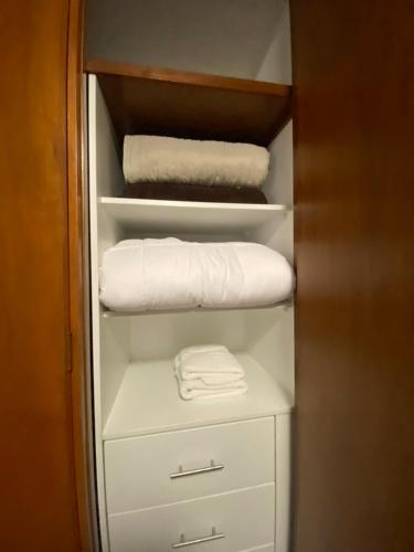 a closet with white towels on a shelf at Vistamar Duplex in Lima