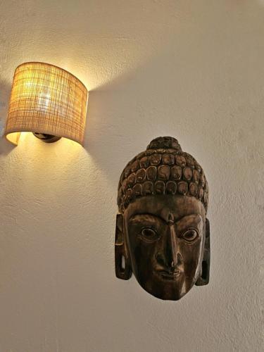 a mask on a wall with a light on it at Casas Rurales Los Molinos in Sanlúcar de Guadiana