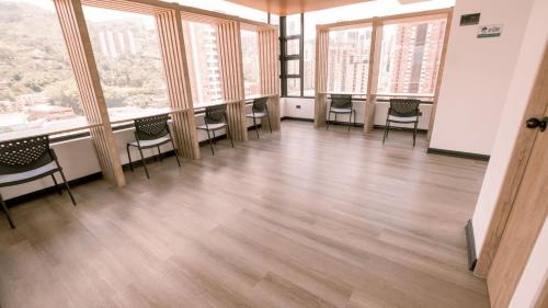 an empty room with chairs and windows at Apartamento Premium Sabaneta in Sabaneta