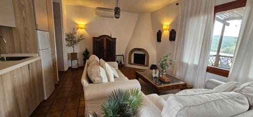 a living room with two white couches and a table at Casas Rurales Los Molinos in Sanlúcar de Guadiana