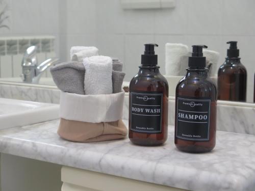 two bottles of soap and towels on a bathroom counter at House of Jane-2 Free PRIVATE Parkings - in Rapallo