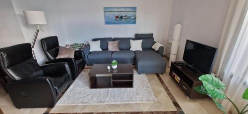 a living room with a couch and chairs and a tv at Casa Colina Roda Golf in San Javier
