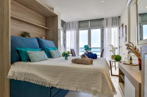 a bedroom with a large bed with a blue headboard at Estudio Loft Horizonte Playa Fossa Calpe in Calpe