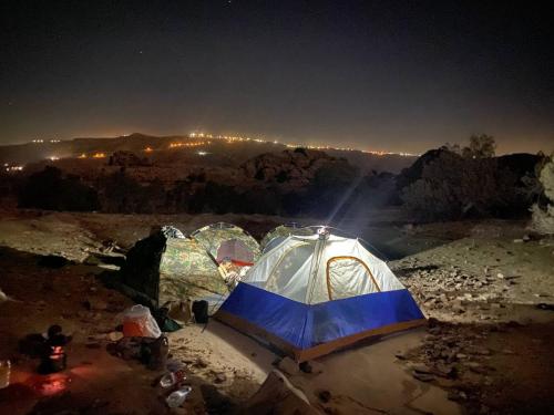 a group of tents in a field at night at Bedouins camp in Dana in At-Tafilah
