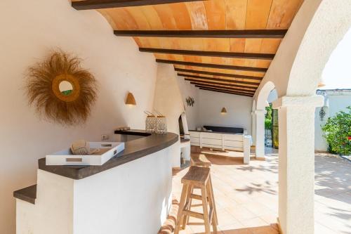 eine Außenküche mit Holzdecke und Bar in der Unterkunft Ca La Mina in Jávea