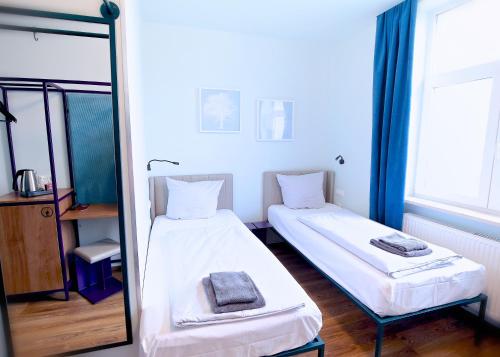 two beds in a room with a mirror at Das Schreder Hotel in Munich