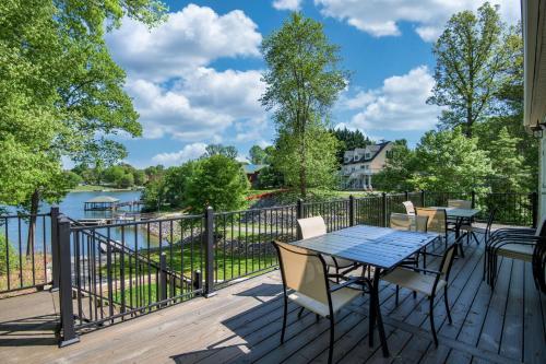 a deck with a table and chairs and a view of the water at Castaway Cove -Lake Norman Waterfront Home with Private Dock in Denver
