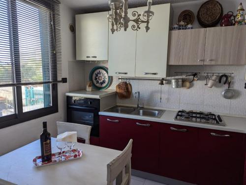 a kitchen with a table with a bottle of wine on it at La Perla Sicula Etna Pool in Agnone Bagni