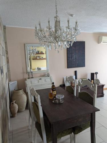 a dining room with a table and a chandelier at La Perla Sicula Etna Pool in Agnone Bagni