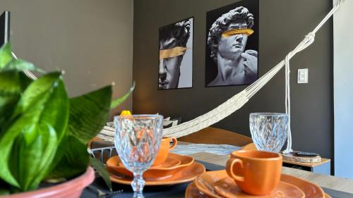 a dining room table with plates and glasses on it at Pelô Flat - Conforto e Cultura em Salvador in Salvador