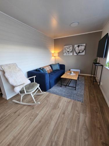 a living room with a blue couch and a table at Comfy and cozy apartment in Tromsø