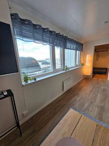 a living room with a large window and a television at Comfy and cozy apartment in Tromsø