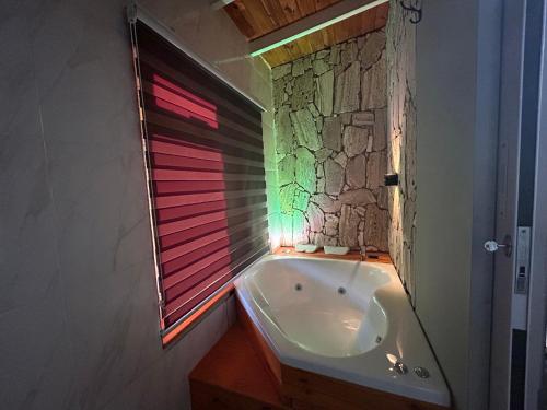 Un baño con bañera y ventana. en Cabañas Balcones de Nogolí - San Luis, en Hipólito Yrigoyen