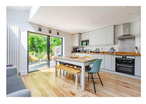 a kitchen with a table and chairs in a room at Stylish Brighton Haven, Sleeps 1 to 7, free parking in Brighton & Hove