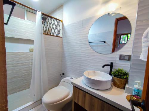 a bathroom with a sink and a toilet and a mirror at Hospédate en Oiba con estilo WIFI TERRAZA in Oiba
