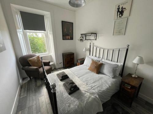 a bedroom with a bed and a chair and a window at Rothesay, Isle of Bute in Rothesay