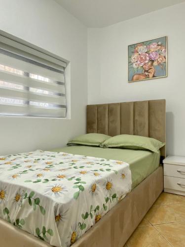 SeaScape APT في دوريس: غرفة نوم بها سرير مزين بغطاء سرير مزهر