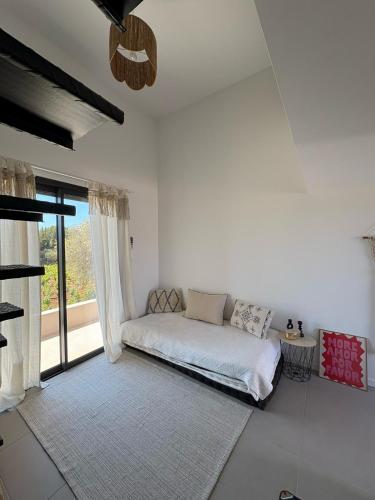 une chambre blanche avec un lit et une fenêtre dans l'établissement Studio terrasse aperçu mer vignes, à Saint-Cyr-sur-Mer