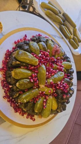 un plato de comida con pepinillos en una mesa en ايدون هاوس, en Aydūn