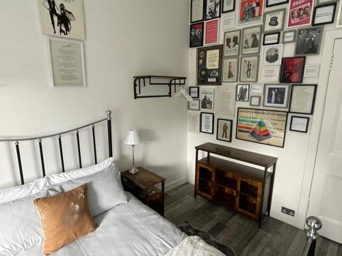 a bedroom with a bed and a wall of pictures at Rothesay, Isle of Bute in Rothesay
