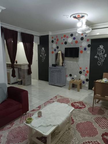 Una sala de estar con un sofá y un televisor. en ايدون هاوس, en Aydūn