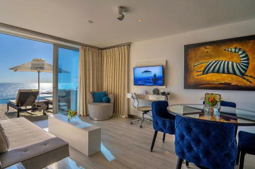 a living room with a couch and a table with chairs at Atlanticview Cape Town Boutique Hotel in Cape Town