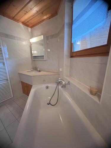 a white bath tub in a bathroom with a sink at Villars SWISS Alpes in Villars-sur-Ollon