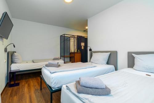 a room with two beds with towels on them at Das Schreder Hotel in Munich