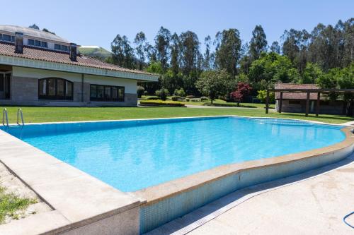 a swimming pool in a yard with a house at Quinta da Estivada in Gondomar