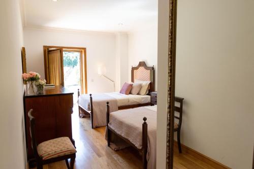 GondomarにあるQuinta da Estivadaのベッドが2つと鏡があるホテルの部屋
