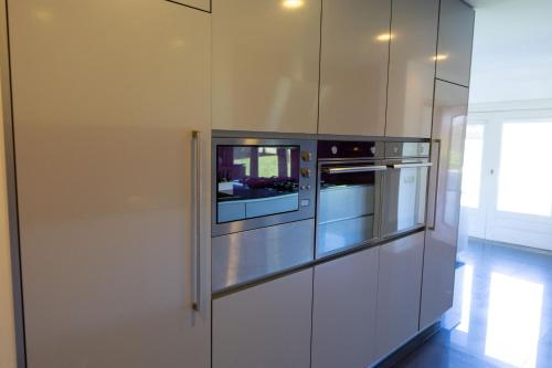 a kitchen with white cabinets and an oven at Quinta da Estivada in Gondomar