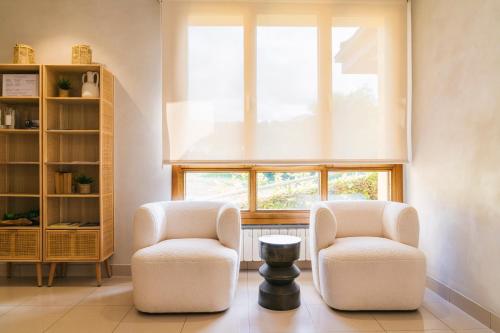 two chairs and a table in a room with a window at Apartamentos Albatros in Barro de Llanes
