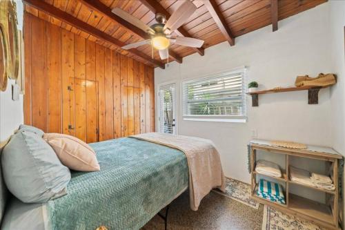 Un dormitorio con una cama y un ventilador de techo. en Cozy Beach-side Bungalow!, en Cabo Cañaveral