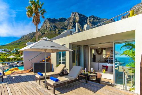 a patio with a table and an umbrella at Atlanticview Cape Town Boutique Hotel in Cape Town