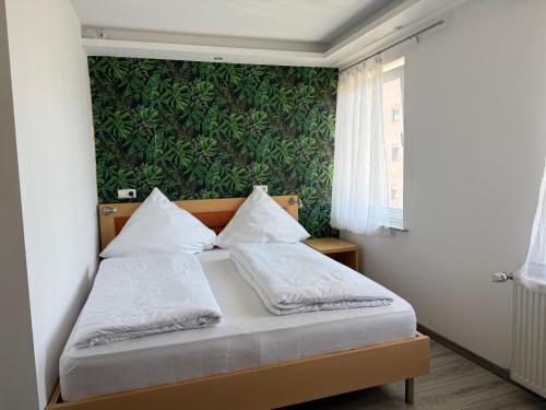 a bed in a room with a green wall at CoBa in Baden-Baden