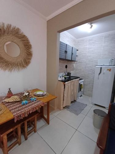 a kitchen with a table and a refrigerator at PÉ NA AREIA APTO 708 in Ubatuba