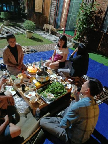 a group of people sitting around a table with food at Moc's House bắc hà in Bắc Hà