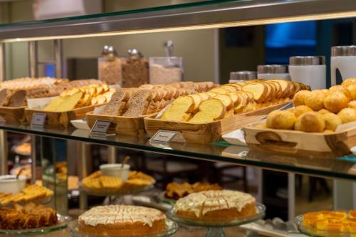 a display case filled with lots of different types of bread at Del Rey Quality Hotel in Foz do Iguaçu