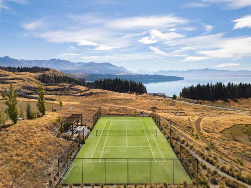 a tennis court on top of a hill with a lake at Mt Cook Lakeside Retreat in Lake Pukaki
