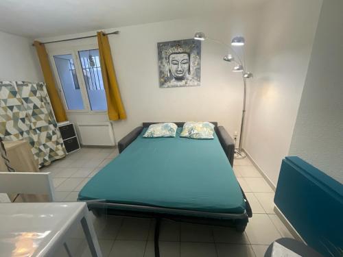 une chambre avec un lit dans une chambre avec une lampe dans l'établissement Petit studio coquet à côté des Halles, à Narbonne