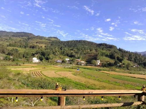 a view of a field with a wooden fence at Moc's House bắc hà in Bắc Hà