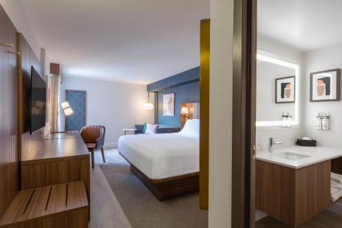 a hotel room with a bed and a sink at Holiday Inn & Suites Winnipeg Downtown by IHG in Winnipeg