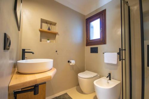 a bathroom with a sink and a toilet at Fico d'India Suite - Veranda Privata e Giardino in Porto Rotondo