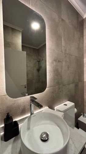 un baño con lavabo y espejo en Allá Ité-Mamboretá, en Sierra de los Padres