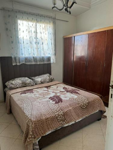 タンジェにあるNice apartment in Tangierのベッドと木製のヘッドボードのある寝室