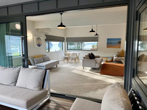 a living room with couches and a dining room at Kaiteriteri Reserve Apartments in Kaiteriteri