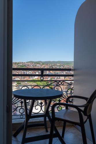 a table and chairs on a balcony with a view at Downtown Apartments in Pristina