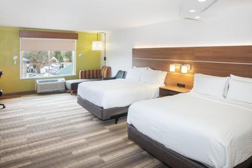 a hotel room with two beds and a couch at Holiday Inn Express and Suites Stroudsburg-Poconos by IHG in Stroudsburg