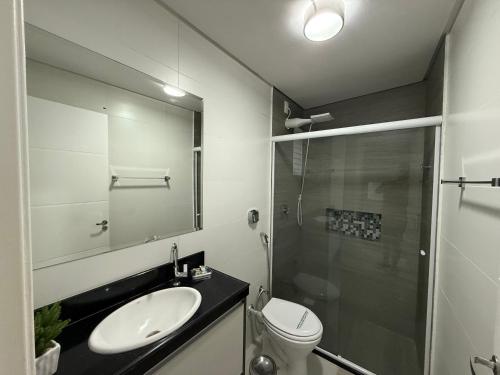 a bathroom with a sink and a shower and a toilet at Apartamento frente mar in Balneário Camboriú
