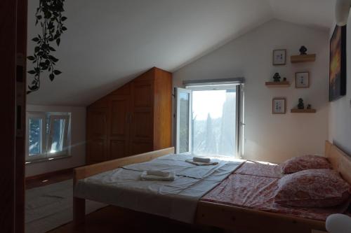 a bedroom with a bed and a large window at Solar Hill Home in Žrnovo